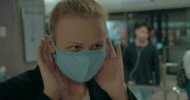 Young blond woman wearing surgical mask in the entrance of clinic Hong Kong, China video