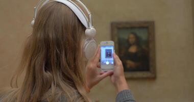 vrouw met cel nemen schot van mona lisa in rooster video