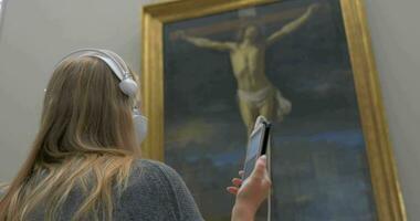 Woman listening to audioguide in the art gallery video