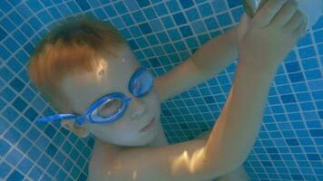 chico en gafas de protección participación aliento en nadando piscina video