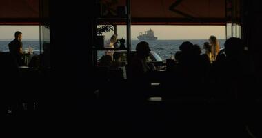 personas en calle café en frente al mar video