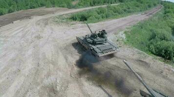 Flying over tank driving on rough ground in the woods video