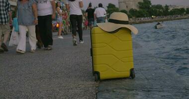 Suitcase with summer on hat it in crowded waterfront video