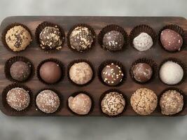 Assorted gourmet truffles on a wooden board black background photo
