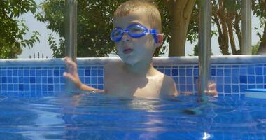 sorridente ragazzo nel occhiali nel nuoto piscina video