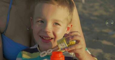 liten Lycklig barn blåser bubblor utomhus- video