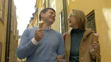 contento uomo e donna mangiare gelato durante un' camminare video