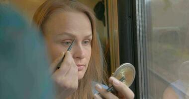 mujer yendo por tren y poniendo en maquillaje video