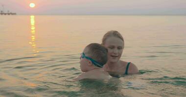 madre enseñando pequeño hijo a nadar video