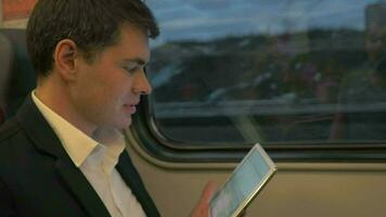 Mens in trein lachend Bij tablet video