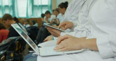 medisch studenten gebruik makend van laptop en stootkussen Aan de lezing video