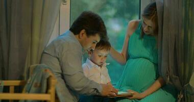 niño muestra algo en tableta a sus padres video