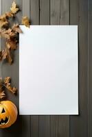 Halloween blank sheet of paper with pumpkin and leaves on wooden background photo