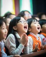 Cute asian school kids clapping their hands in the classroom photo