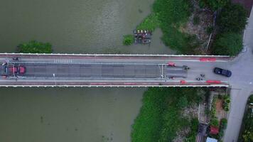 Repair of a concrete bridge across a river in the countryside. Repair of a road section. Aerial view of renovation of the bridge. dangerous passage video