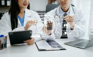 Medical technology network team meeting concept. Doctor hand working with smart phone modern digital tablet and laptop computer with graphics chart interface, with virtual icon diagram photo