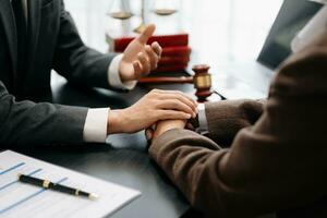 Business people compassionately holding hands and discussing contract papers with laptop and tabletat office photo