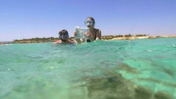 Tourists diving to take photo of coral reef video