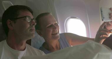 joven Pareja haciendo selfie con célula en avión video