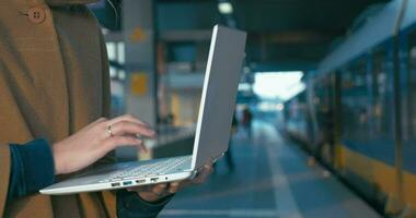 ragazza Lavorando con il computer portatile a il ferrovia stazione video