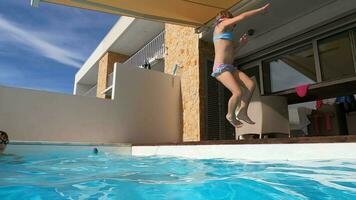 Girl's playful pool jump in slow motion video