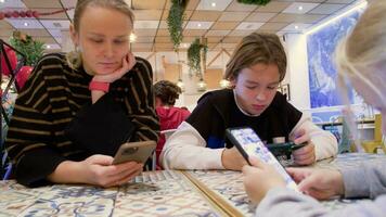 mam en kinderen zijn Aan hun telefoons in een cafe - 2 video