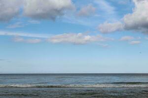 The front view in the morning sky is bright blue with clear white clouds. And the ocean deep indigo in daylight. Feeling calm, cool, relaxing. The idea for cold background and copy space on the top. photo