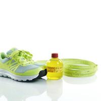 Conceptual health and lifestyle image with running shoes, water bottle, and a heart-shaped measuring tape symbol photo