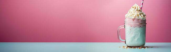 Cotton candy-topped milkshake in a jar against a pink background photo