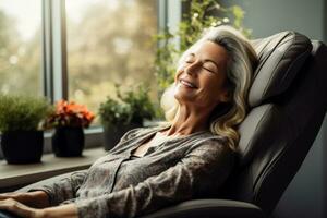 Senior woman lounging and napping on an electric massage chair in the living room photo