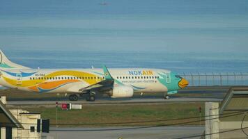 PHUKET, THAILAND NOVEMBER 26, 2016 - Boeing 737 Nok Air taxiing on the runway before takeoff against the backdrop of the azure sea at Phuket Airport. Tourism and travel video