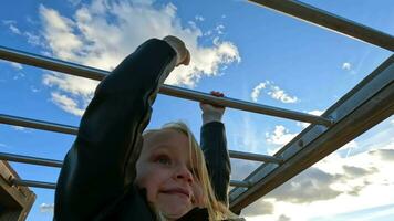 Kid is hanging monkey bar at the playground video