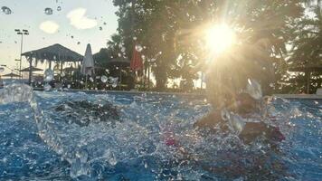 Brother and sister play in the pool in the evening video