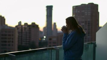 Urban woman drinking tea on the balcony in early morning video