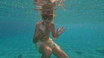 adolescente mergulhos embaixo da agua e acenando video