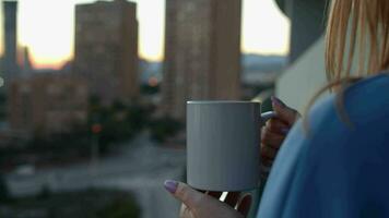mulher tendo quente chá em a apartamento sacada dentro a manhã video