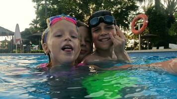 tre bambini giocando nel il piscina video