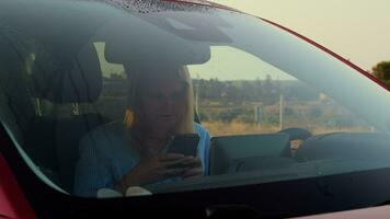 Female car driver with phone in the countryside video