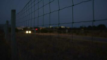 Evening view of a country road along the wire metal fence video