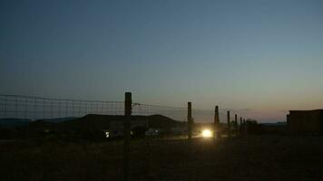 Few cars on remote country road along the fenced area in the dusk video