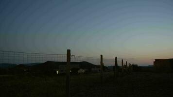 Car on the country road with wire metal fence alongside, dusk view video