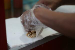 rolling finished kebabs manually for customers. photo