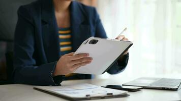 business woman working with digital tablet computer and smart phone with financial business strategy layer effect on desk video