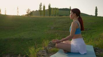 Yoga trainieren von weiblich Athlet. jung gesund Frau tun Yoga im das Berge während Sonnenaufgang. Wohlbefinden und gesund Lebensstil, Zen Konzept. schleppend Bewegung. video