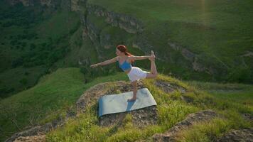 yoga sesión en el montañas. joven atlético mujer hacer ejercicio en el rocoso montañas durante amanecer, haciendo varios yoga poses - sano estilo de vida y zenismo concepto. lento movimiento. video