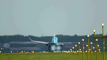 Rückseite Aussicht von ein Flugzeug Landung, berühren Nieder und Bremsung mit Rauch. Landung Beleuchtung erleuchten das Runway. filmisch Aufnahmen von Flugzeug Flug Ankunft video