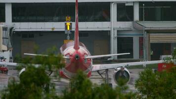 Rear view of a jet passenger plane taxiing to the terminal after landing. video