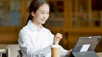 Woman typing documents in laptop with coffee at work time video