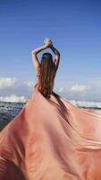 Girl in a long dress against the backdrop of the ocean in Bali. Vertical video. video