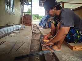 kuaro Kalimantan timur, Indonesia 10 septiembre 2023. un constructor es corte hierro utilizando un amoladora foto